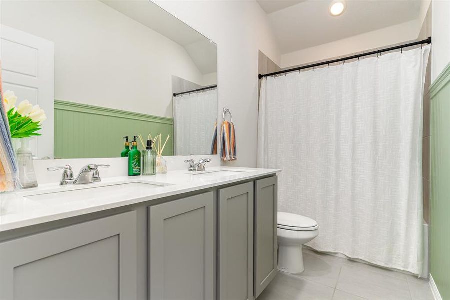 Bathroom featuring vanity, walk in shower, toilet, and tile patterned flooring