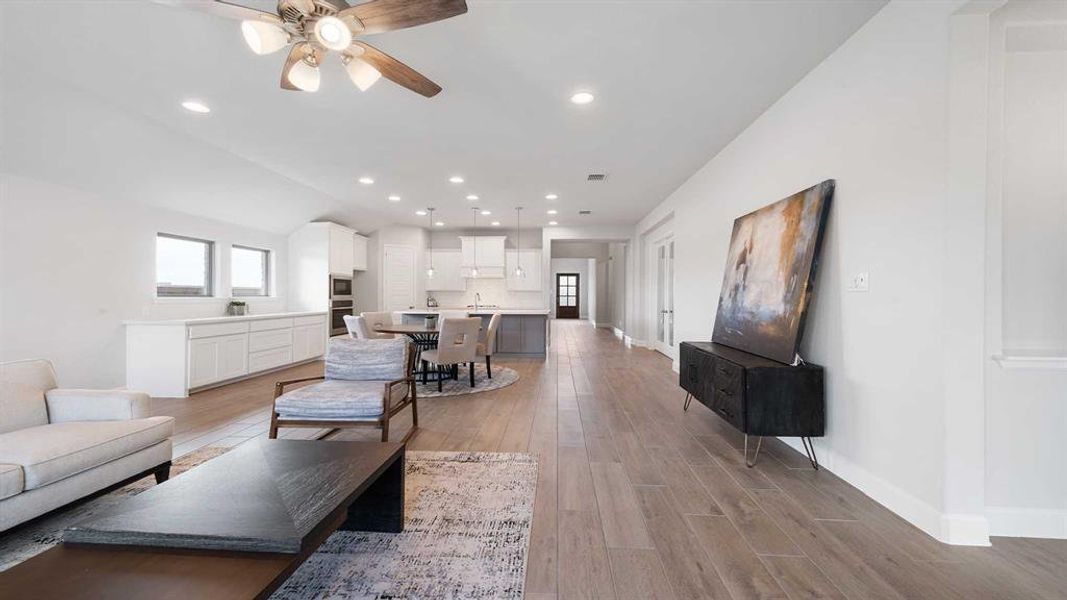 Living room with ceiling fan and light hardwood / wood-style flooring