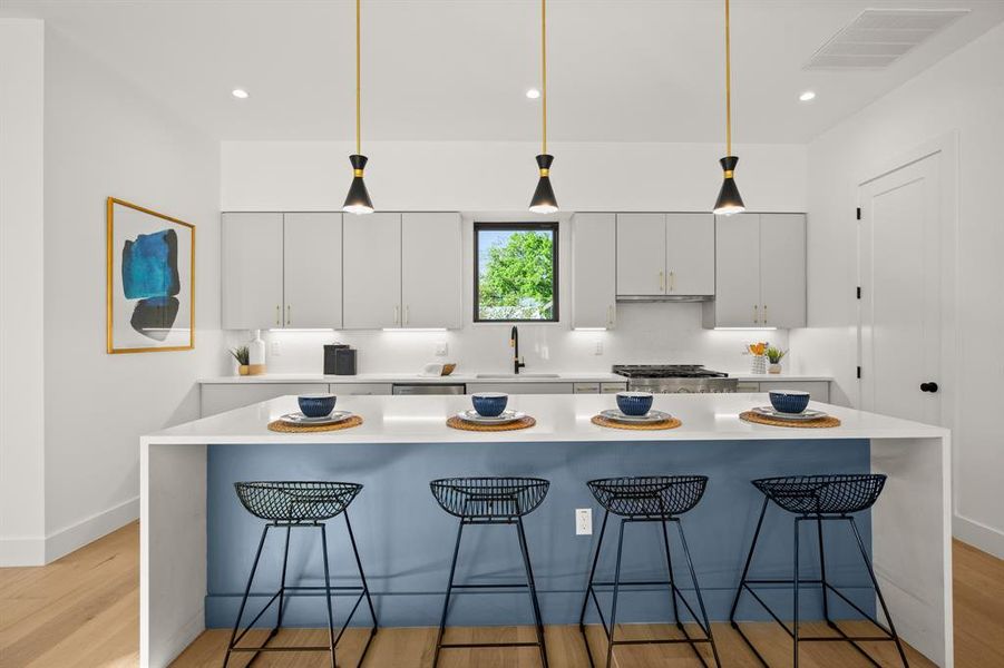 Amazing oversized entertainer's center island with quartz waterfall countertops and seating four four that everyone will want to gather around.