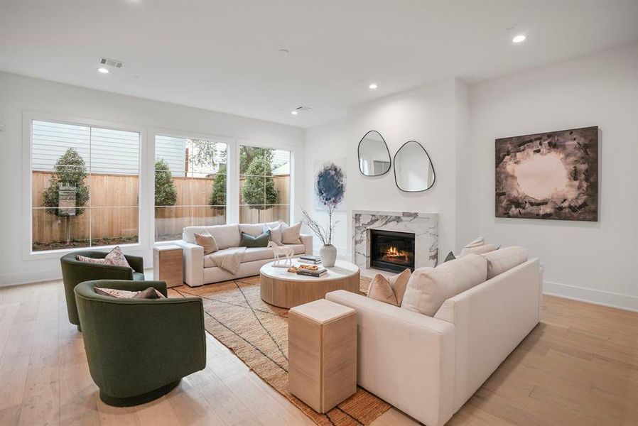 This living room is grand enough for large sectionals and other full-sized pieces of furniture. Enjoy conversations by the gas log fireplace overlooking beautiful backyard trees.