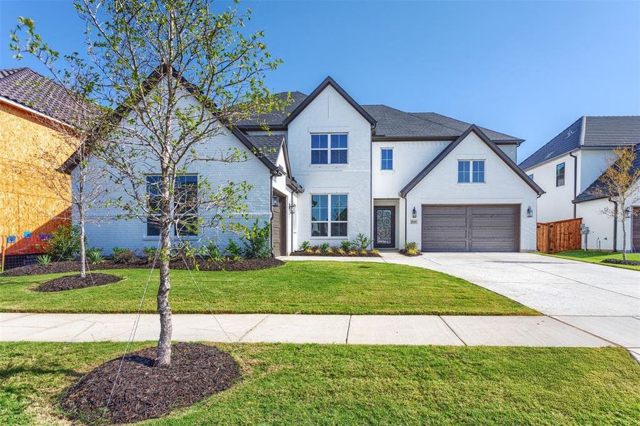 View of front of home featuring a front yard and a garage