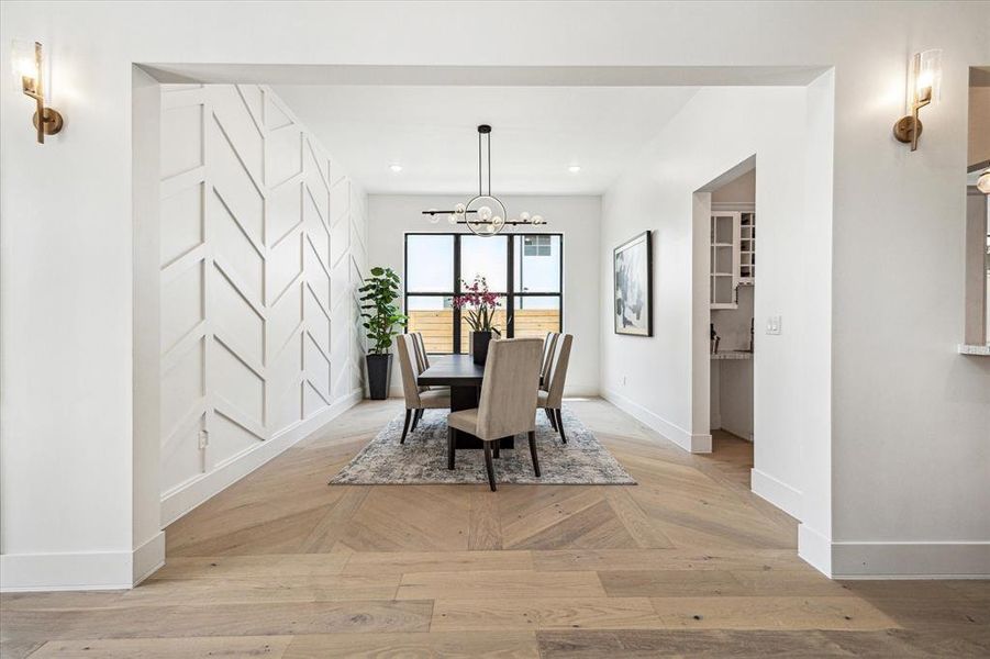 The elegant dining room features a custom wood paneled wall, creating an ambiance perfect for entertaining