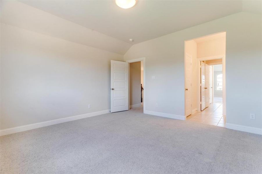 Spare room with lofted ceiling and light colored carpet