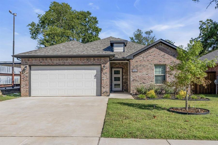 View of front of house with a front lawn and a garage