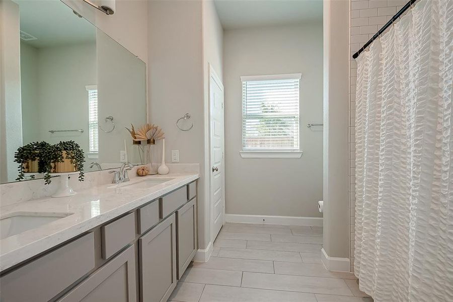 Secondary bathroom features atub/shower combo and long vanitywith dual sinks and plenty of counter space.