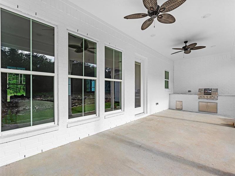 The oversized backyard patio is enhanced by two ceiling fans and a fully equipped kitchen powered by propane.