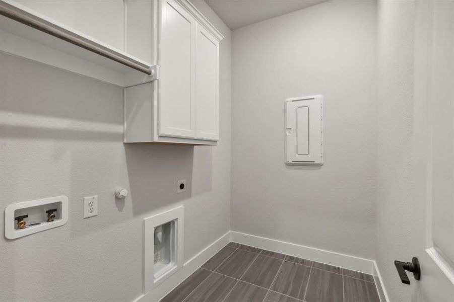 Clothes washing area featuring cabinets, electric dryer hookup, electric panel, washer hookup, and hookup for a gas dryer