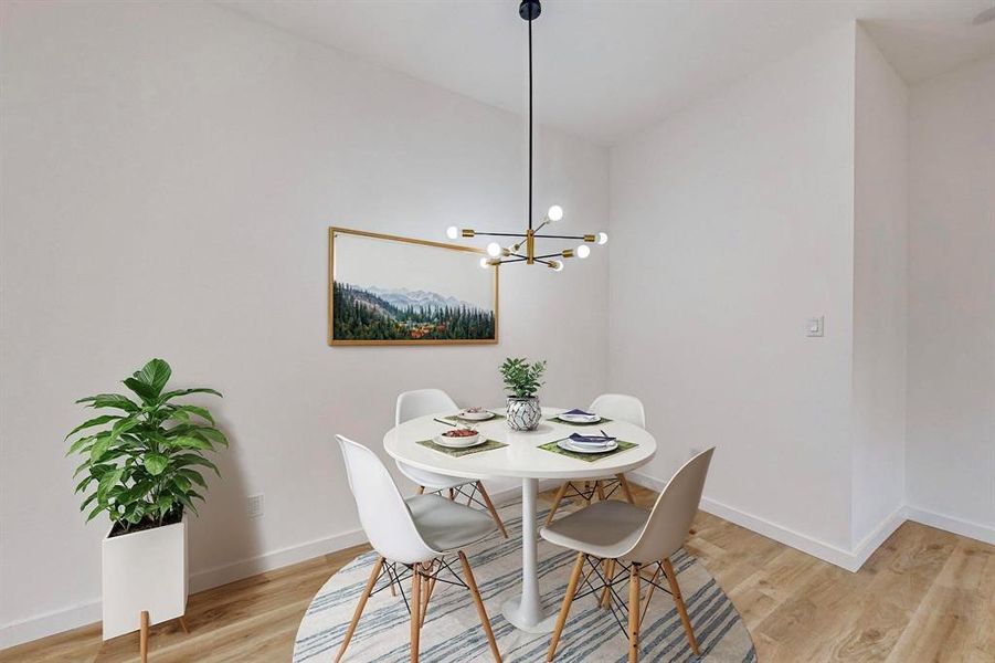 Dining room with light wood-type flooring and an inviting chandelier