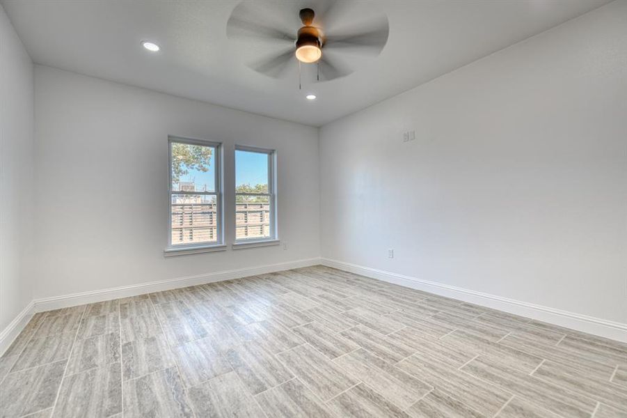 Empty room with light hardwood / wood-style flooring and ceiling fan