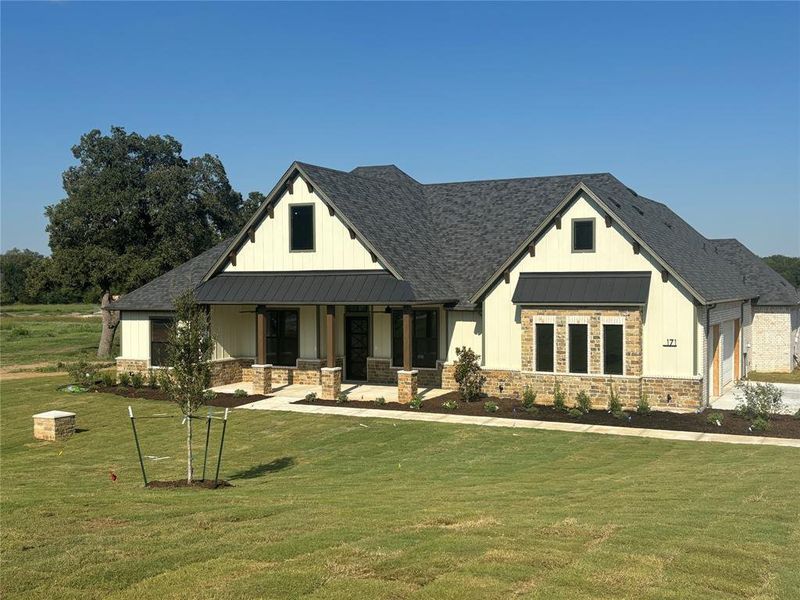 Modern farmhouse style home with a porch and a front lawn