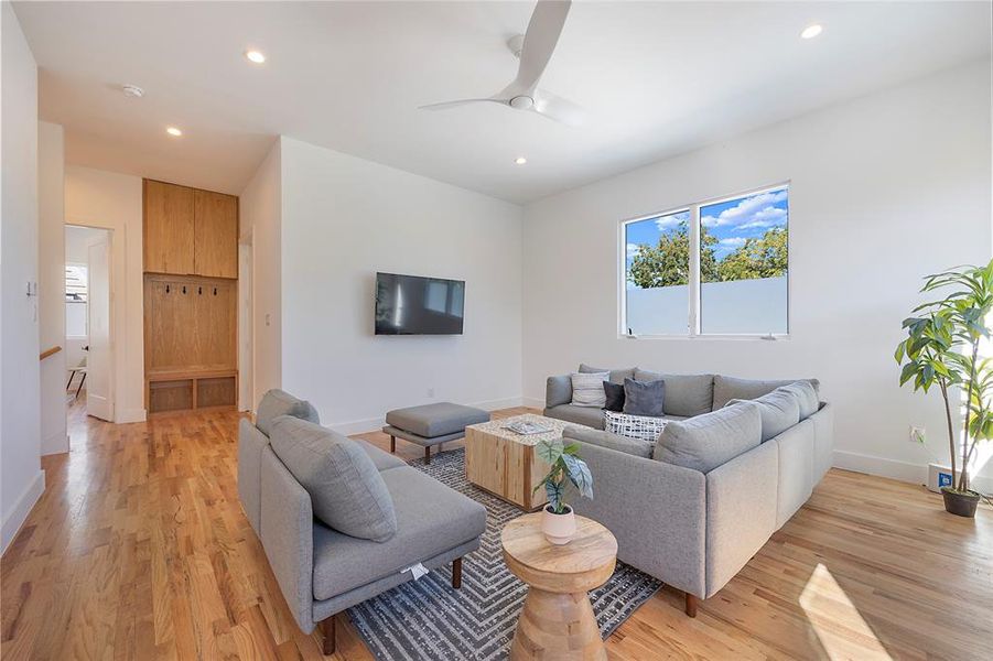 Living room with light wood-type flooring and ceiling fan