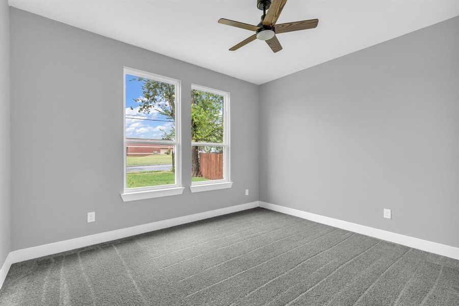 Carpeted spare room with ceiling fan