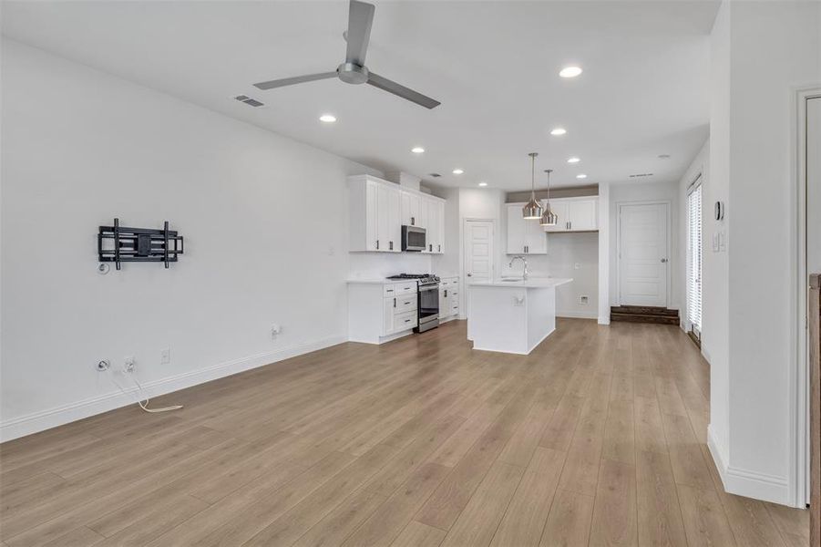 Living room featuring sink, ceiling fan, and light hardwood / wood-style flooring