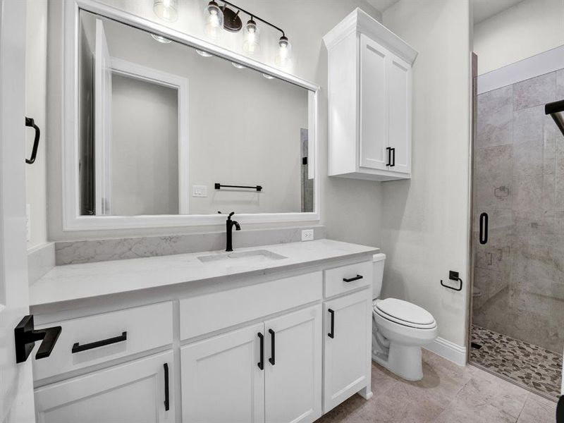 Bathroom with vanity, tile patterned floors, toilet, and walk in shower