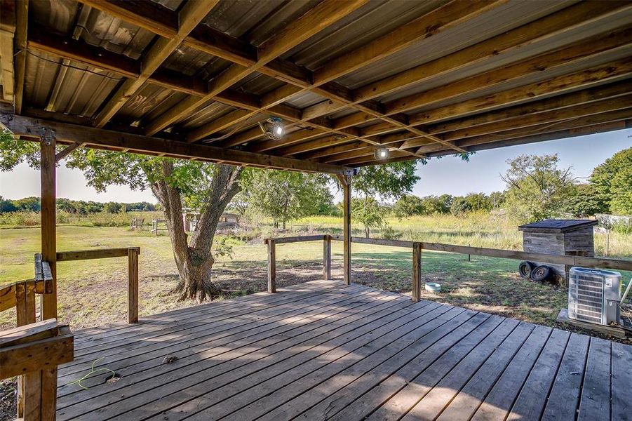 Wooden terrace featuring central AC unit and a rural view