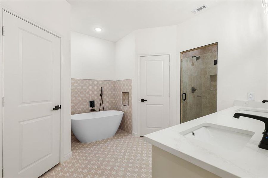 Bathroom with tile patterned flooring, independent shower and bath, and double sink