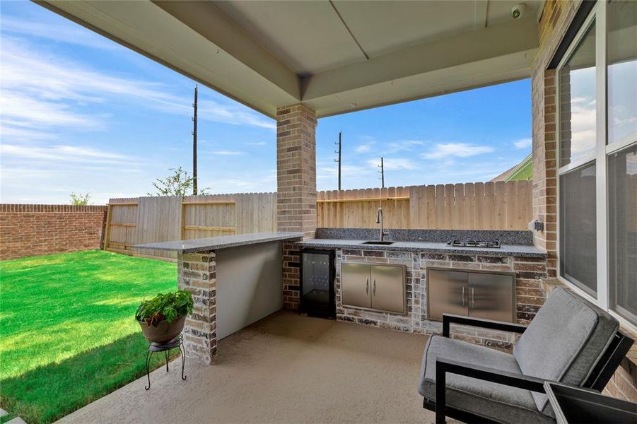 Custom Outdoor Kitchen Included - Bar area with additional backyard greenspace, showcasing a feature not found in new construction homes, included at no extra cost.