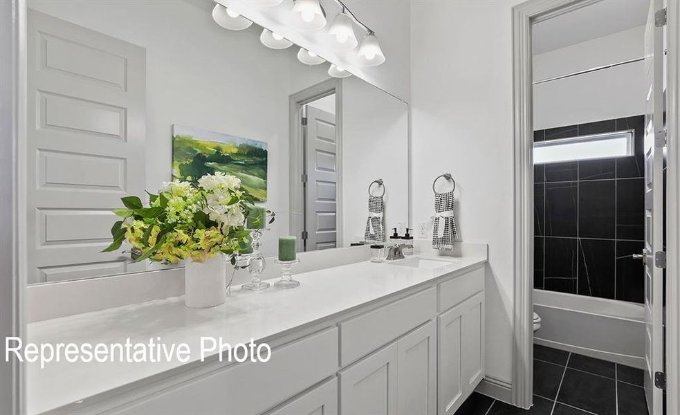 Full bathroom featuring tile patterned floors, toilet, tiled shower / bath, and vanity