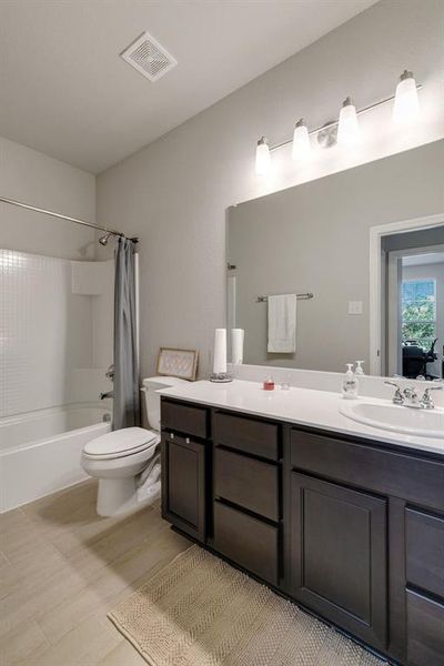 Full bathroom featuring tile patterned floors, vanity, shower / tub combo, and toilet