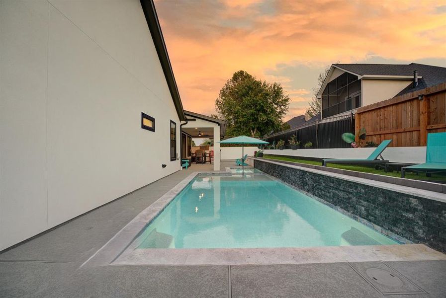 An inviting pool and spa seamlessly blends with the overall aesthetic of this home.