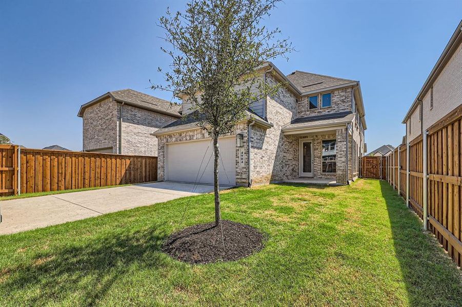 View of front of property featuring a garage and a front lawn