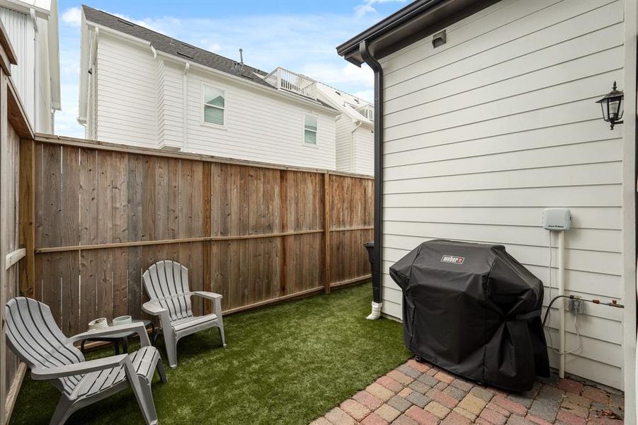 The backyard features turf and solid board fencing for more privacy.