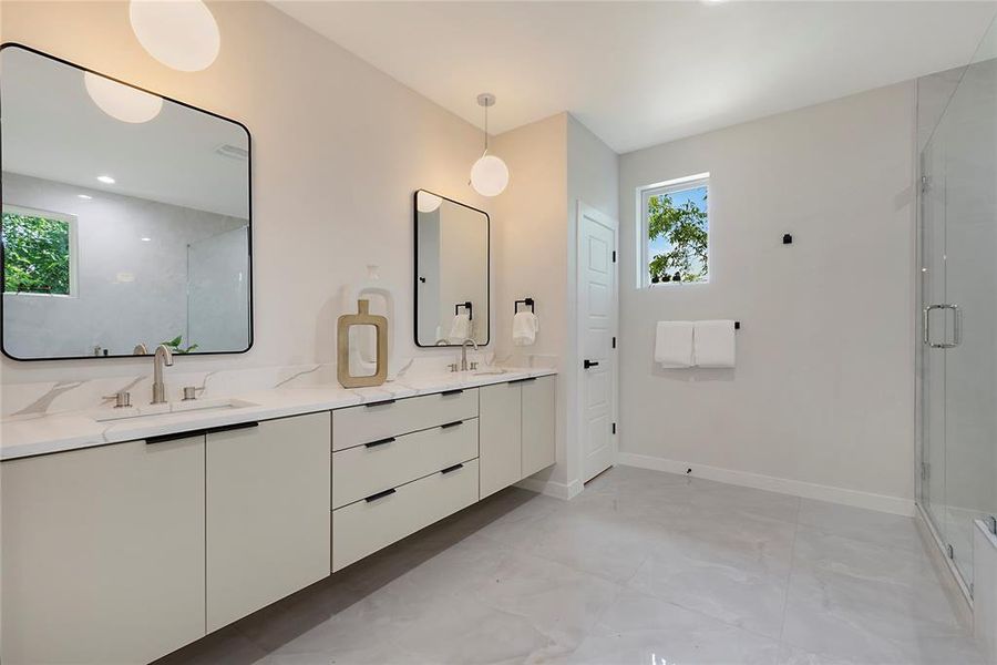 Primary bathroom featuring dual vanity, walk in shower, plenty of natural light, and tile patterned floors