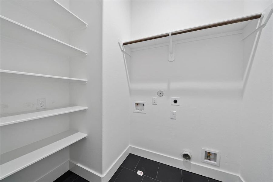 Utility room upstairs with built-in shelving for additional storage.