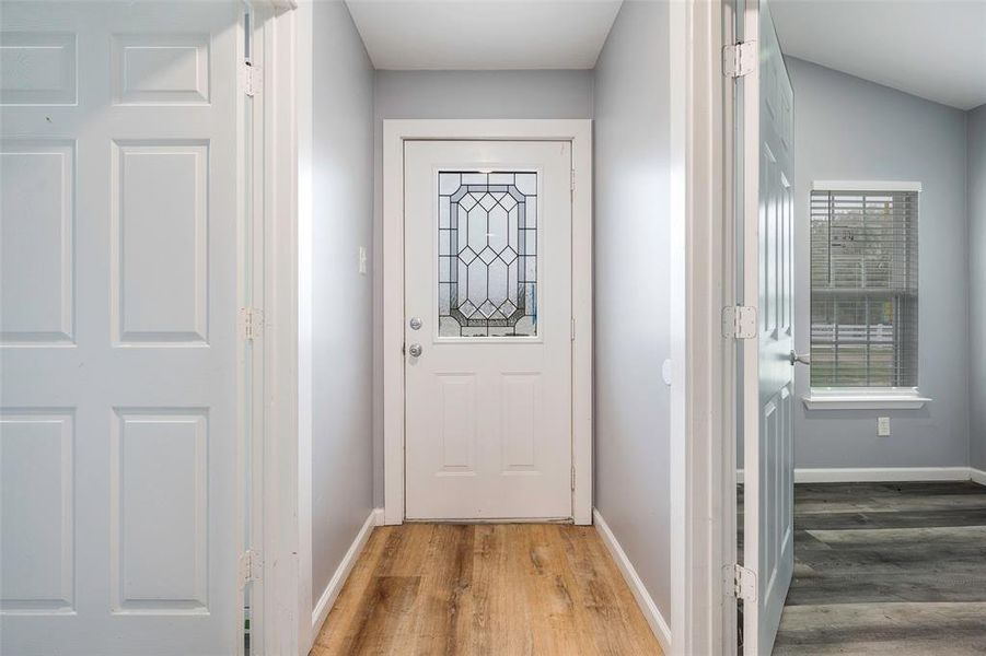 Doorway featuring hardwood / wood-style flooring and vaulted ceiling