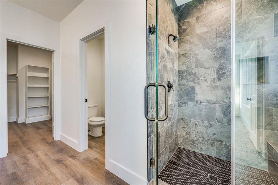 Bathroom with walk in shower, wood-type flooring, and toilet