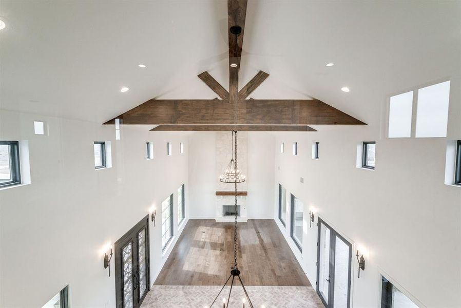 Hall with high vaulted ceiling, french doors, an inviting chandelier, light hardwood / wood-style flooring, and beam ceiling