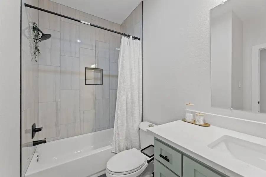 Full bathroom featuring toilet, vanity, and shower / tub combo