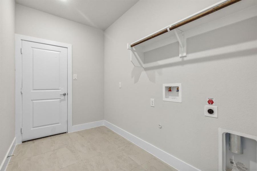 Laundry area with washer hookup, hookup for an electric dryer, light tile patterned floors, and hookup for a gas dryer