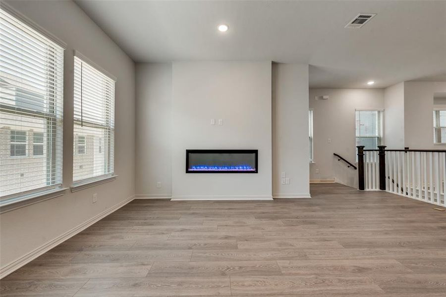 Unfurnished living room featuring light hardwood / wood-style flooring and a healthy amount of sunlight