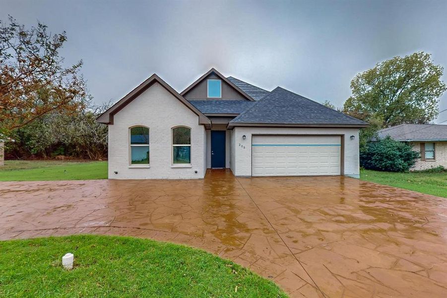 View of front of house with a garage and a front yard