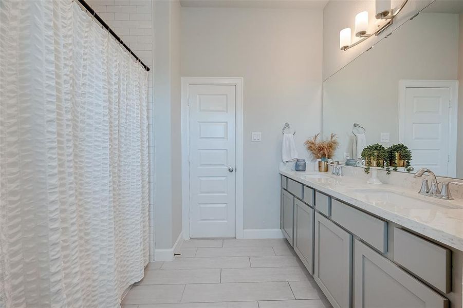 Secondary bathroom features atub/shower combo and long vanitywith dual sinks and plenty of counter space.