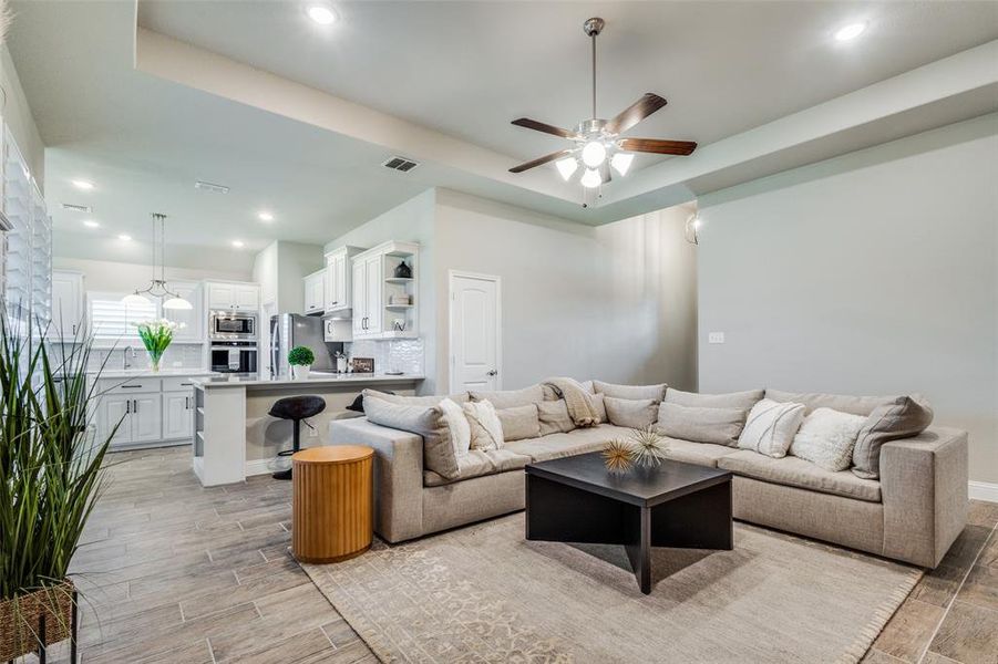 Living room with a tray ceiling and ceiling fan