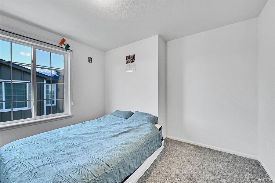 A second bedroom is found on the upper level and offers plush carpet flooring, plenty of space and a large window allowing light to shine in.