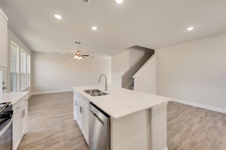 Kitchen featuring an island with sink, light hardwood / wood-style floors, appliances with stainless steel finishes, and sink