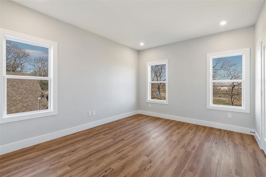 Empty room with a healthy amount of sunlight and wood-type flooring