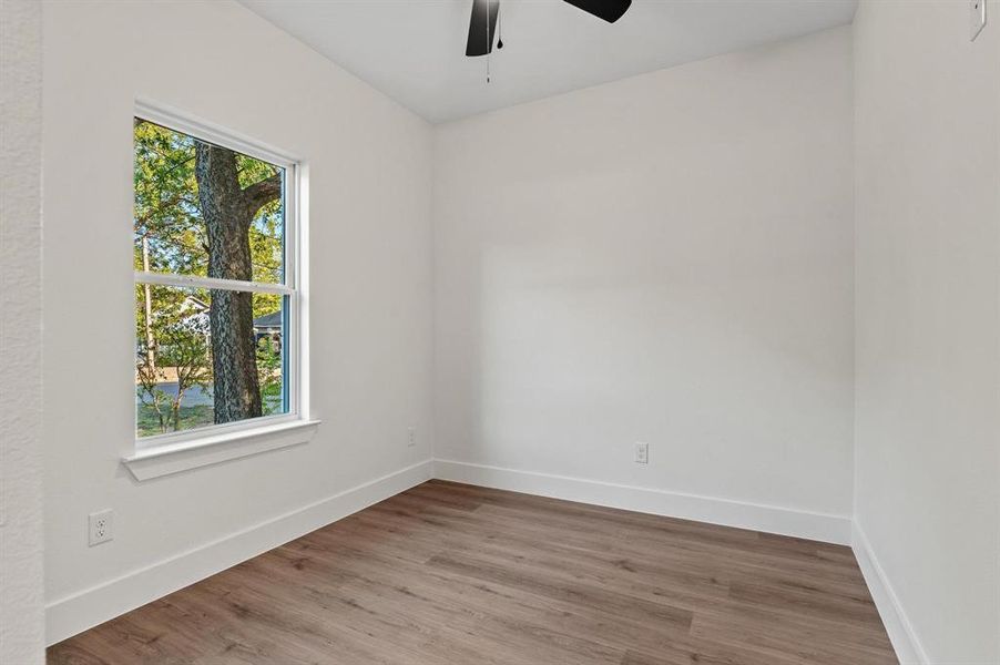 Empty room with hardwood / wood-style flooring and ceiling fan