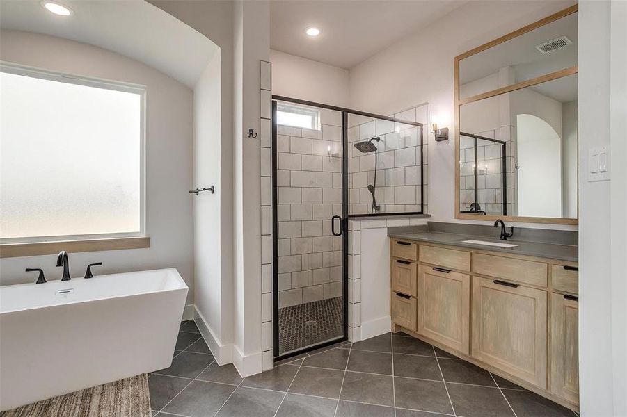 Bathroom featuring vanity, tile patterned flooring, plus walk in shower, and a wealth of natural light