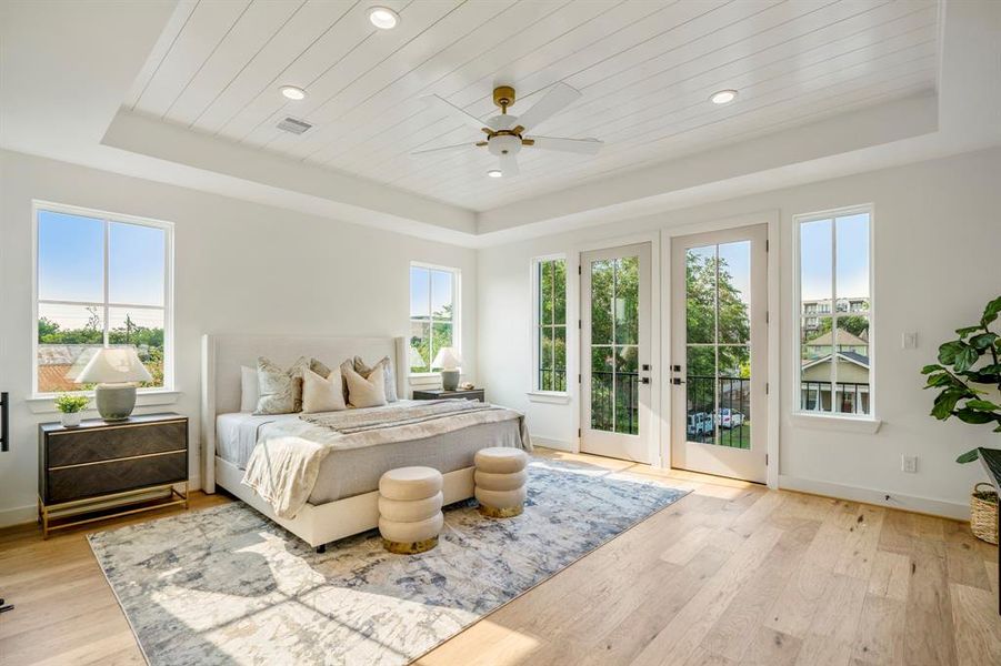 This is your sanctuary. This primary bedroom with tray ceilings is grand with double French doors leading to your balcony.