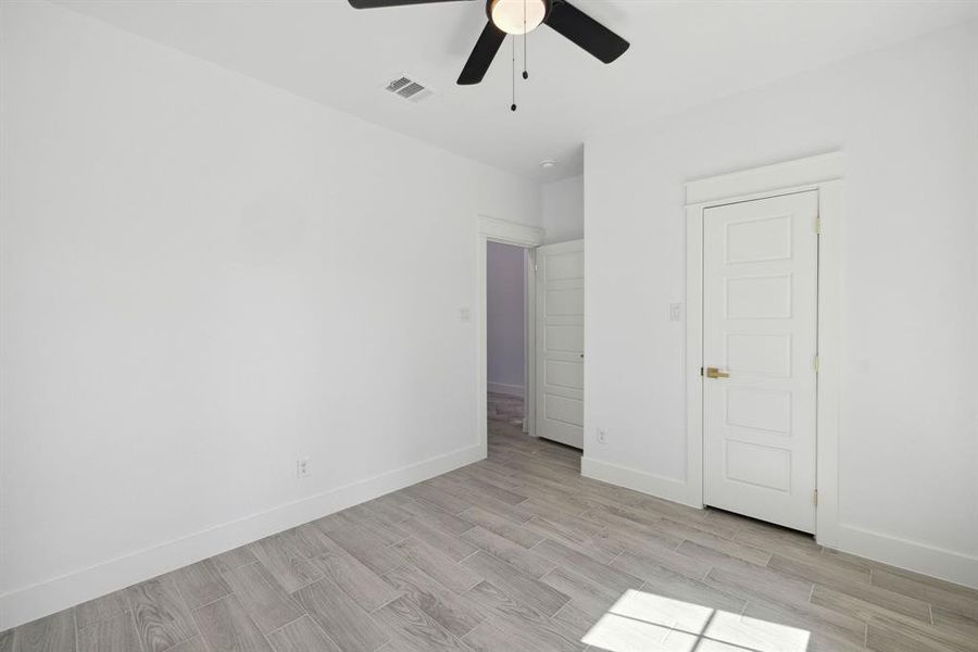 Unfurnished bedroom with ceiling fan and light wood-type flooring