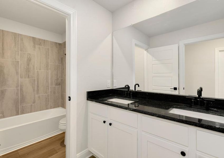 Secondary bathroom with a dual-sink vanity and dual shower and tub.