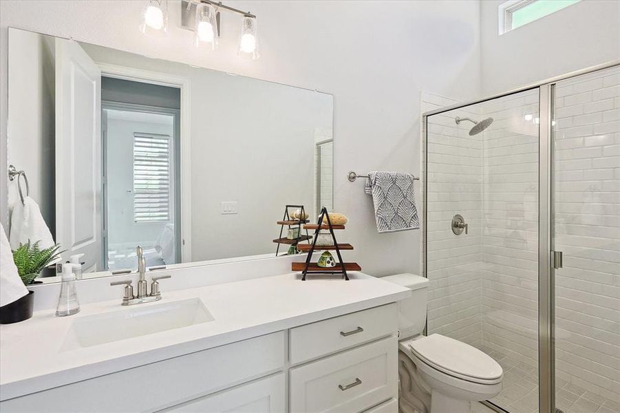 Bathroom featuring vanity, toilet, and a shower with shower door