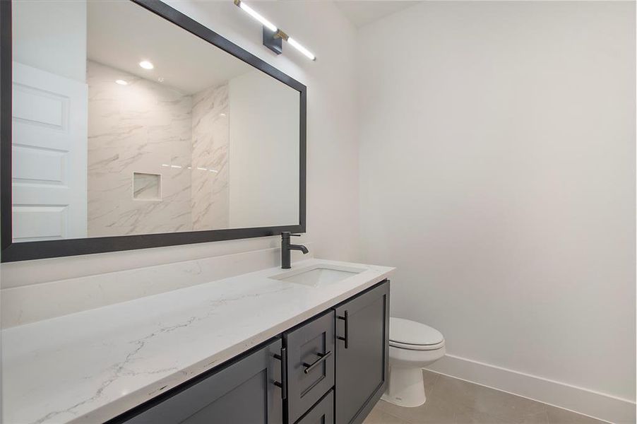 Bathroom with vanity, toilet, and tile patterned floors