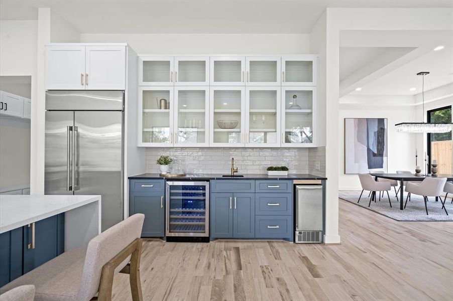 Closer view of the extended kitchen cabinets and bar area, with secondary sink, wine fridge, and built-in ice maker/