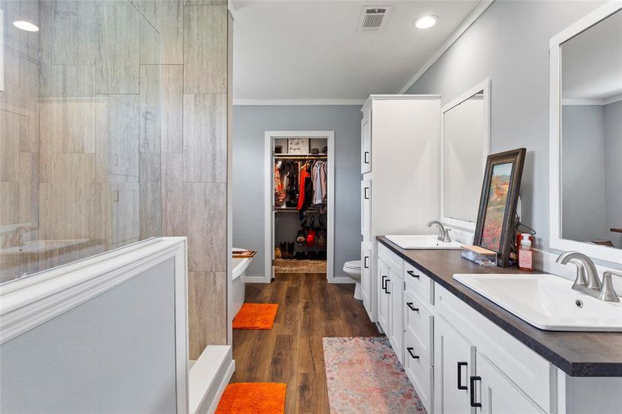 This bathroom is spa-like.  Full walk-in shower, soaker tub, two sinks, lots of storage, and the floors make it easy to keep clean and bright.
