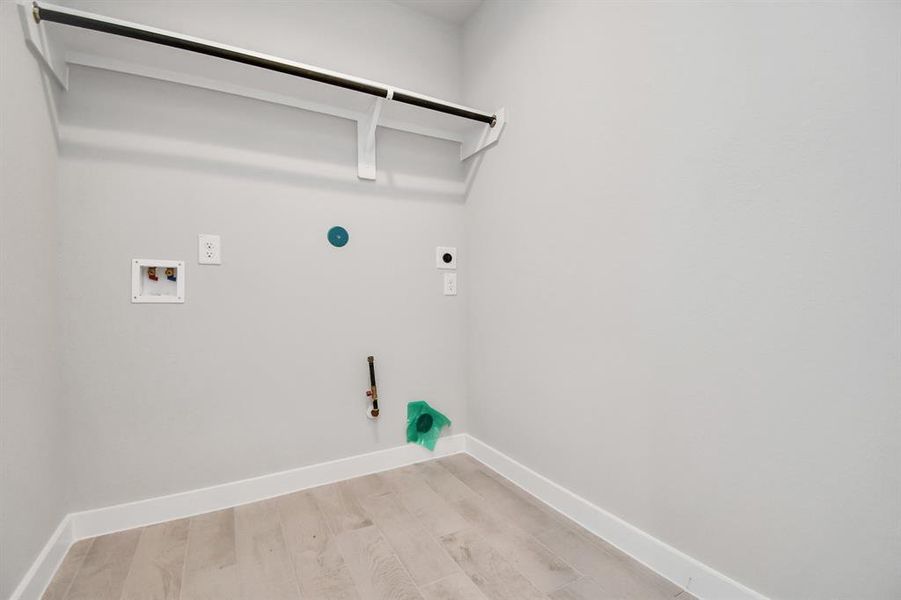 A perfect blend of functionality and comfort. Laundry room, thoughtfully equipped with shelving for effortless organization. Both gas and electric dryer connections available. Sample photo of similar plan. As-built color and selections may vary.